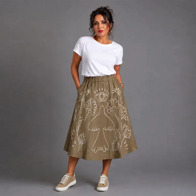 Vista frontal de falda midi de gamuza caqui con diseño artesanal pintado a mano de aves y flora mexicana moderna