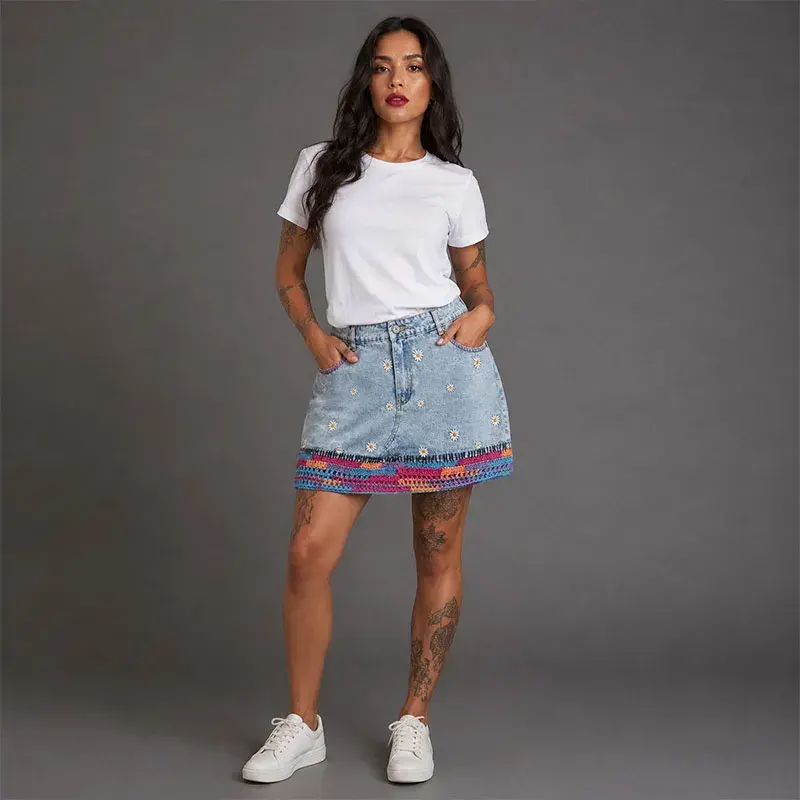 Falda denim claro con margaritas bordadas y crochet multicolor en el borde inferior - Arte portable Trece31